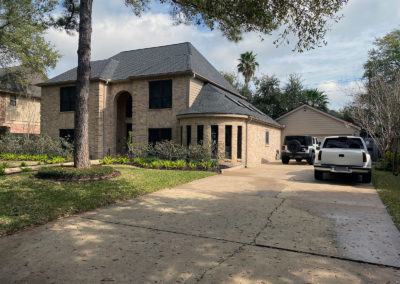 A house with two cars parked in front of it.